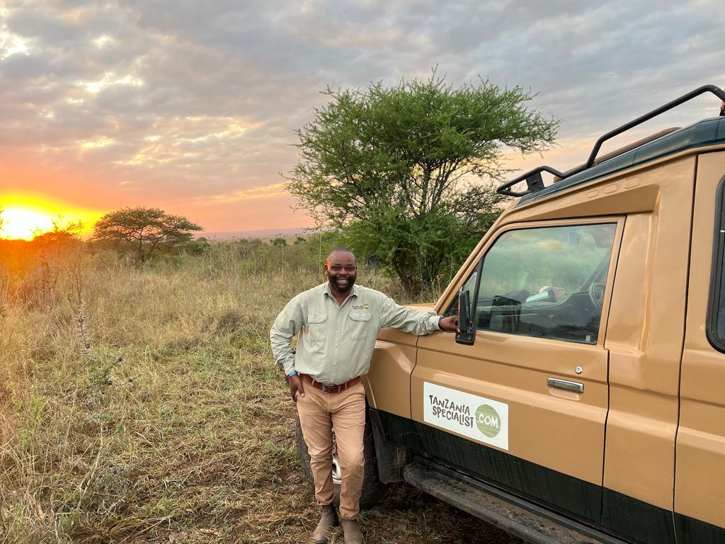 Reiseekspert i Tanzania foran bil fra Tanzania Specialist.