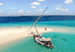 En båt i turkisblått hav ved strand i Tanzania