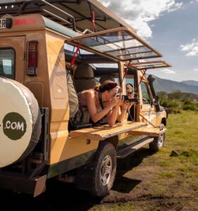 Mennesker tar bilde fra jeep på safari i Tanzania