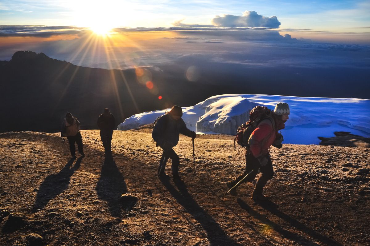 Flerdagsturer i Tanzania. En gruppe turgåere på Kilimanjaro i soloppgang