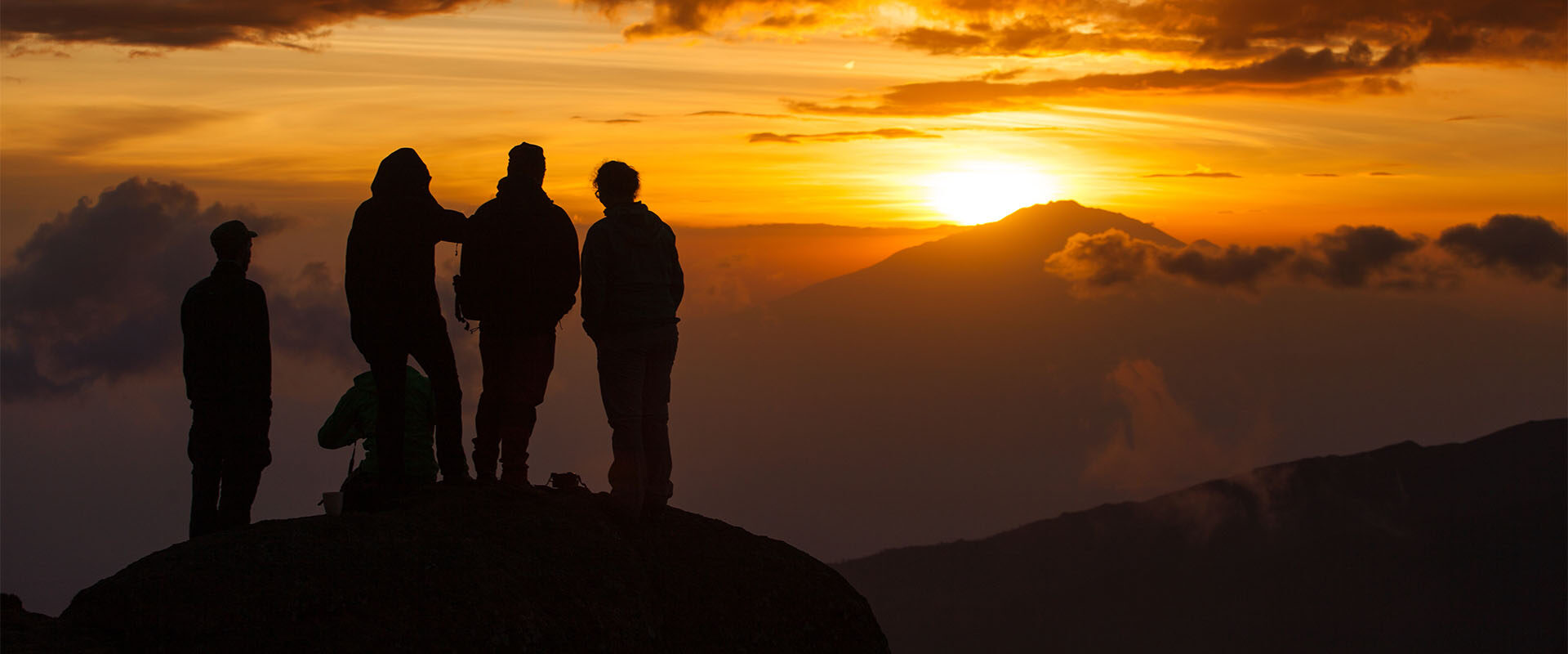 Opplevelsesturer i Tanzania. En gruppe står på Kilimanjaro i solnedgang