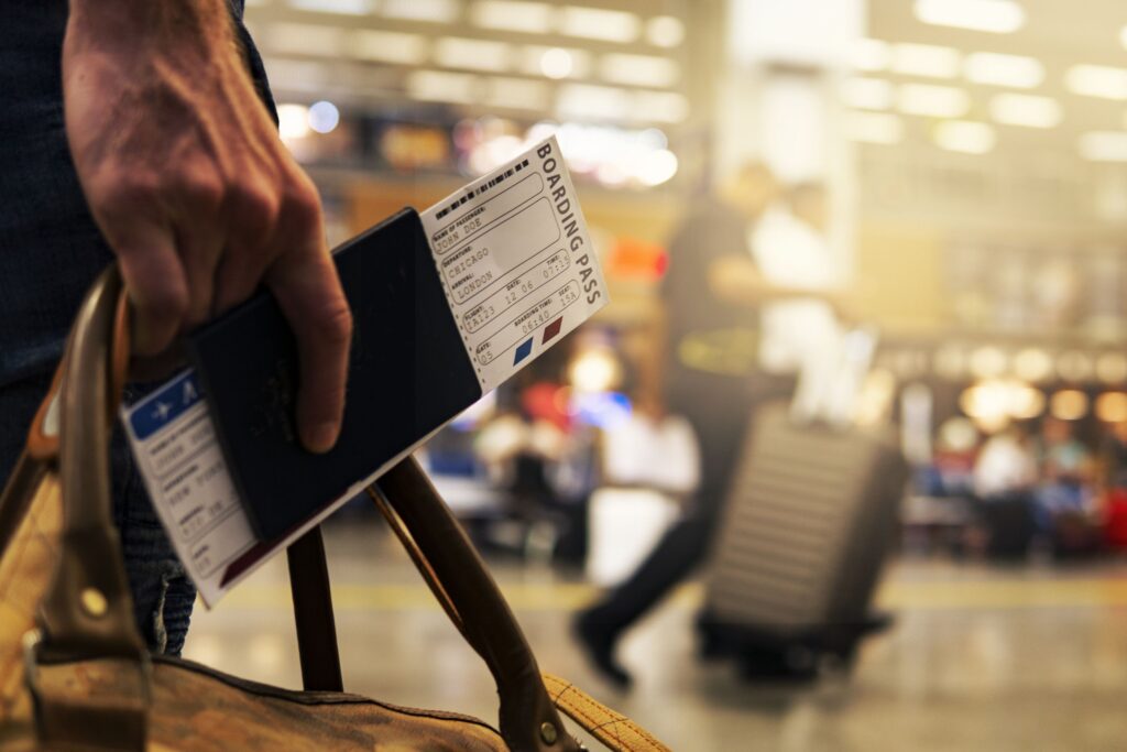 Visum Tanzania. En hånd holder et pass og boarding pass.