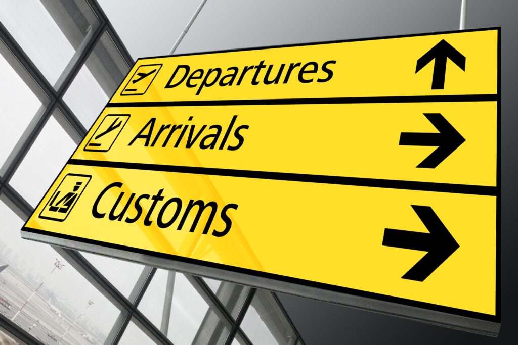Tanzania visum. Gult skilt med piler til departures, arrivals og customs
