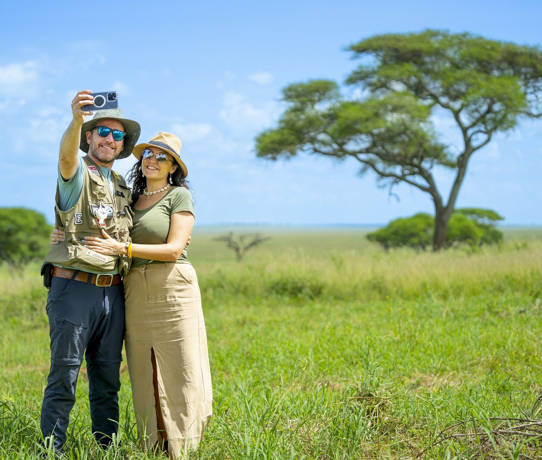 Et par på safari i Tanzania tar en selfie foran et akasietre