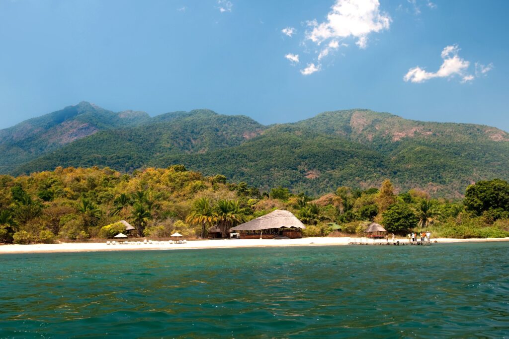 Tanzania-innsjøen Tanganyika med fjell og en hytte i bakgrunnen
