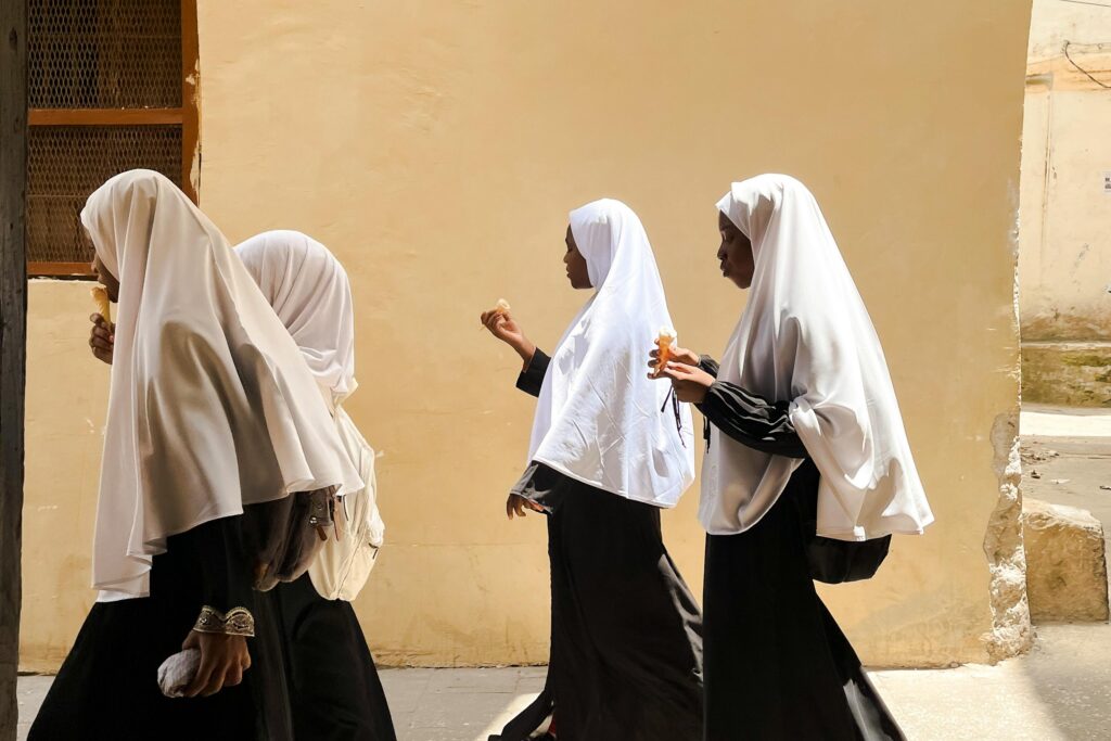 Mote i Tanzania, fire unge jenter kledd i tradisjonelle muslimske klær
