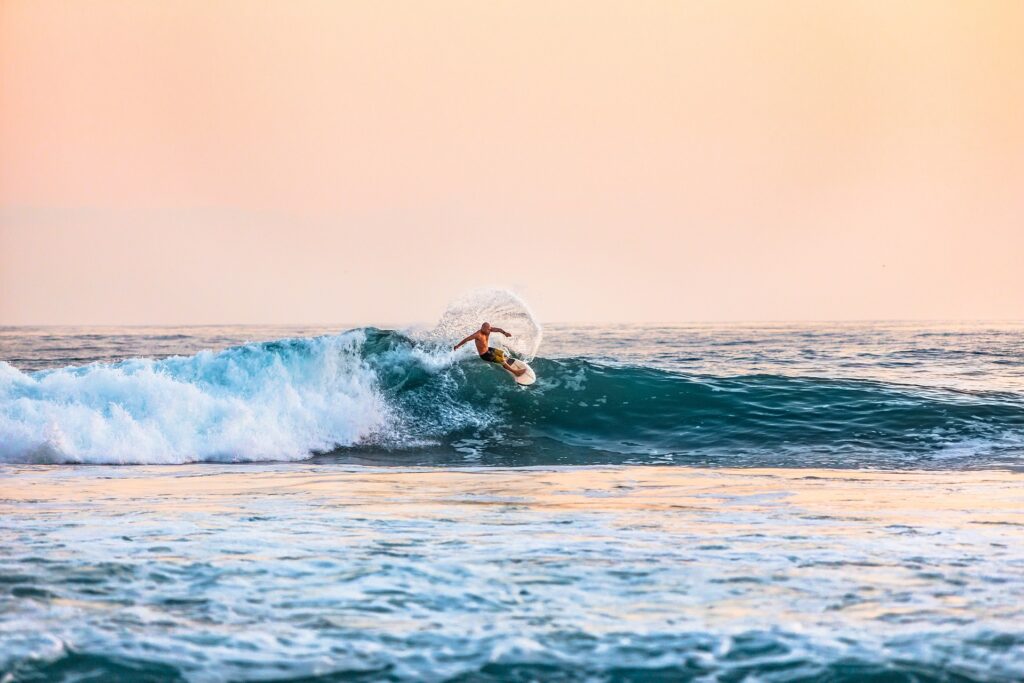 Mann surfer i Tanzania i solnedgang