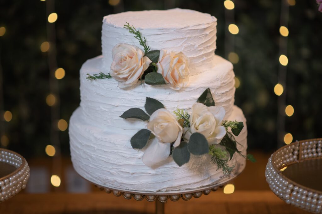 Hvit bryllupskake i tre etasjer med blomster