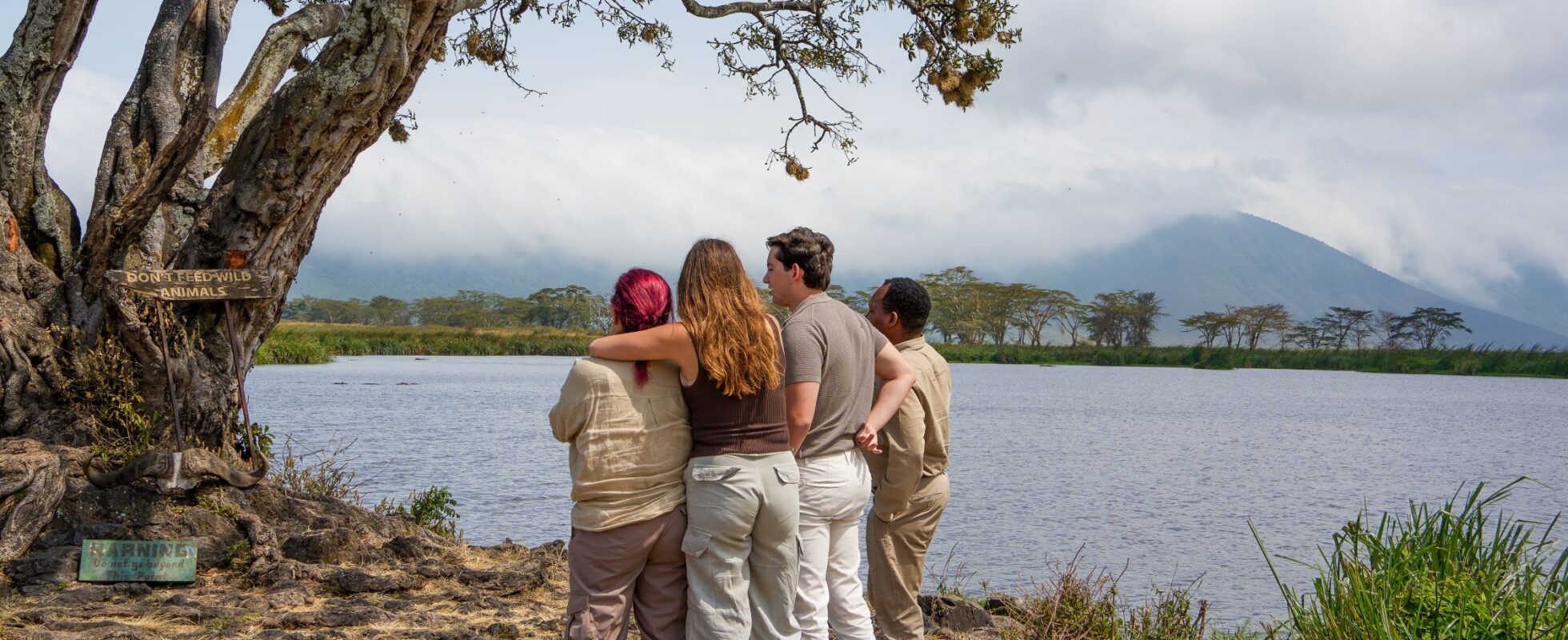 Fire mennesker som ser på naturen arm i arm